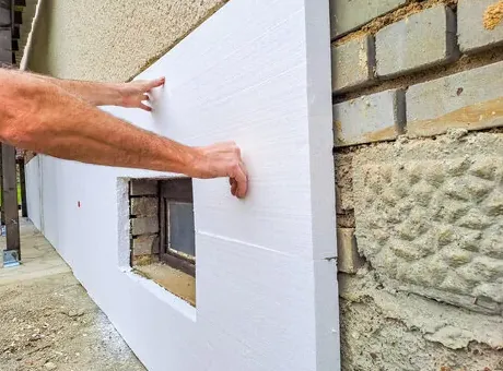 Foam insulation panel pressed onto an exterior wall