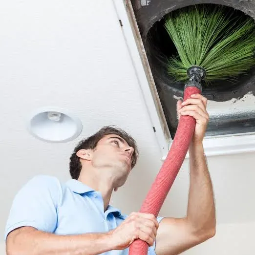 Pasadena technician running a rotary brush through a ceiling air duct